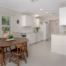 Bright remodeled kitchen with painted white cabinets, quartz countertops, updated flooring, and dining area.
